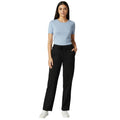 Woman wearing a light blue top and black pants on a white background